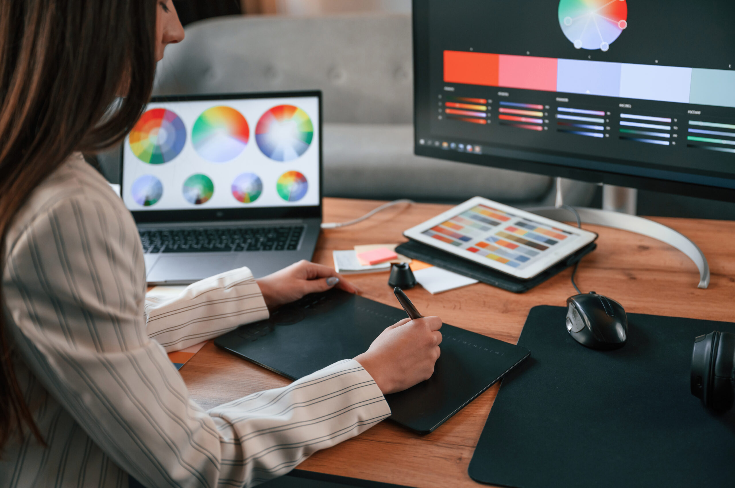 Drawing by using graphic tablet. Woman is working in the modern office with computer.